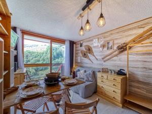 a room with a wooden wall with a table and chairs at Studio Soyouz Vanguard-99 by Interhome in Le Corbier