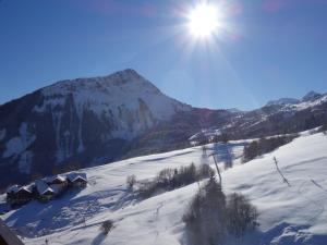 a snow covered mountain with the sun in the sky at Studio Soyouz Vanguard-99 by Interhome in Le Corbier