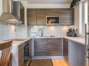 une cuisine avec des armoires en bois et un évier dans l'établissement Holiday Home Kelotähti a 23 by Interhome, à Saariselka