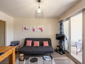 a living room with a couch and a tv at Studio Les Ecureuils-2 by Interhome in Les Mathes