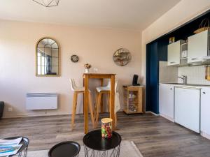 een woonkamer met een tafel en een keuken bij Studio Les Ecureuils-2 by Interhome in Les Mathes