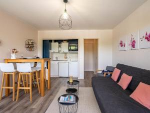 a living room and kitchen with a couch and a table at Studio Les Ecureuils-2 by Interhome in Les Mathes