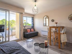 a living room with a couch and a table at Studio Les Ecureuils-2 by Interhome in Les Mathes