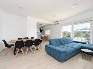- un salon avec un canapé bleu et une table dans l'établissement Holiday Home Anima by Interhome, à Galovac
