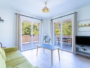 sala de estar con sofá y mesa en Apartment Le Clos Jardin-4 by Interhome, en Bormes-les-Mimosas