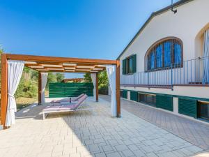 um pátio com uma pérgola e bancos em Holiday Home Villa della Duna by Interhome em Collemezzano