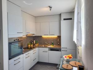 eine weiße Küche mit weißen Schränken und einem Waschbecken in der Unterkunft Apartment Torre Tessuti 3-1 by Interhome in Locarno
