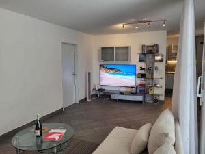 a living room with a couch and a large screen tv at Apartment Torre Tessuti Apt-Stefano by Interhome in Locarno +15 photos