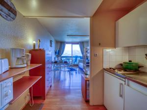 a kitchen with white cabinets and a red refrigerator at Studio Pegase Phenix-73 by Interhome in Le Corbier