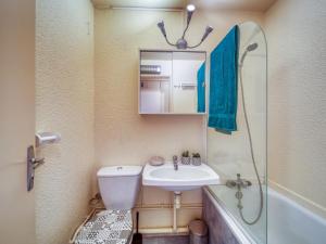 a bathroom with a sink and a toilet and a mirror at Studio Pegase Phenix-73 by Interhome in Le Corbier