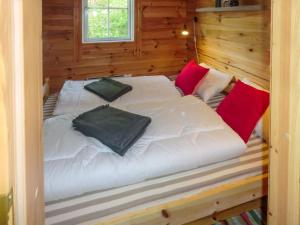 a bedroom with a white bed with red pillows at Chalet Xenia - TEM204 by Interhome in Vradal