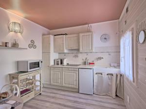 a kitchen with white cabinets and a sink and a microwave at Apartment Jacky by Interhome in Le Pouliguen