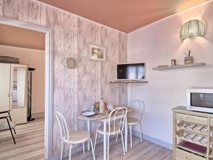 a dining room with a table and chairs and a tv at Apartment Jacky by Interhome in Le Pouliguen