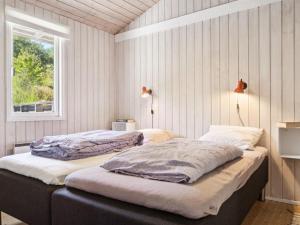2 camas en un dormitorio con ventana en Holiday Home Henryk - 350m from the sea in Djursland and Mols by Interhome en Ørby