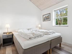 ein weißes Schlafzimmer mit einem Bett und einem Fenster in der Unterkunft Holiday Home Idda - 350m from the sea in NW Jutland by Interhome in Fjerritslev