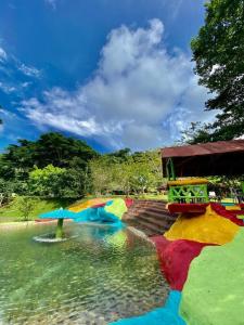 a pond with colorful umbrellas in the water at Hotel Experiencia Viva in Mesa del Norte