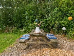 una mesa de picnic con un jarrón encima en Holiday Home Forest Cottage Ewijk incl- hot tub by Interhome, en Ewijk