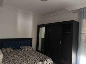 1 dormitorio con 1 cama y armario negro en Appart.kelibia côté la plus belle mer de Tunisie, en Kelibia