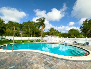 a swimming pool in a yard with a white fence at Dream Home 10 Min To Beach W Shared Pool #21 in Clearwater