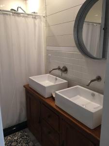 een badkamer met 2 witte wastafels en een spiegel bij Cozy Cottage on the Lagoon 