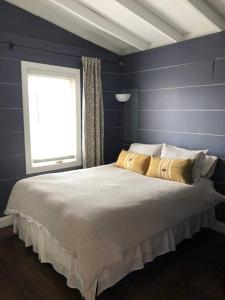 een slaapkamer met een groot bed en een raam bij Cozy Cottage on the Lagoon 