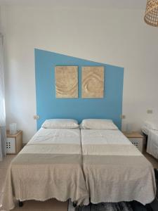 a bedroom with a large bed with a blue headboard at HOME BIJOUX in Rho +5 photos