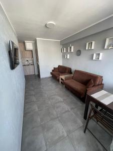 una sala de estar con 2 sofás marrones y una mesa. en HOLIDAY HOME Slavia New 801 z widokiem na morze, en Międzyzdroje