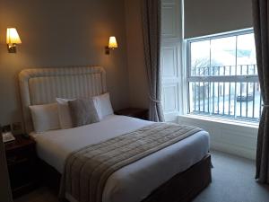 a bedroom with a bed and a large window at The Western Hotel in Galway
