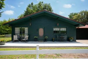 una casa verde con sillas y mesa en Cozy Family-Friendly Getaway, near Austin, en Lockhart