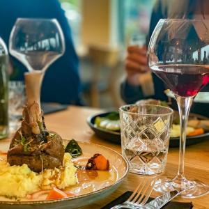 uma mesa com um prato de comida e um copo de vinho em Landbrot Guesthouse em Kirkjubæjarklaustur