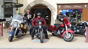 three men are sitting on motorcycles in front of a store at Eterlou in La Chambre