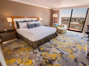 a hotel room with a bed and a large window at Hotel Lucerna Ciudad Juarez in Ciudad Juárez