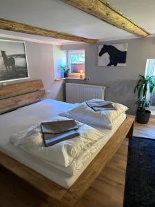 a bedroom with a large white bed with two pillows on it at Allenberghütte Schoningen in Uslar