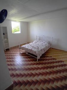 sypialnia z łóżkiem i drewnianą podłogą w obiekcie Résidence Mathurin w mieście Anse-Bertrand