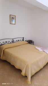 um quarto com uma cama com um cobertor amarelo em Agriturismo Sant' Anna Ortì em Reggio di Calabria