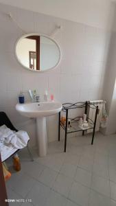 uma casa de banho branca com um lavatório e um espelho em Agriturismo Sant' Anna Ortì em Reggio di Calabria