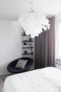 1 dormitorio con 1 cama, 1 silla y 1 lámpara de araña en Nordic sea, en Kołobrzeg
