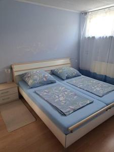 a bedroom with two beds with blue sheets and a window at Schöne 2 Zimmer Wohnung in Fürth