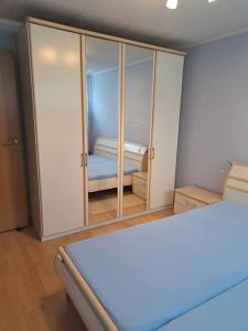 Habitación con dormitorio con cama y espejo. en Schöne 2 Zimmer Wohnung en Fürth