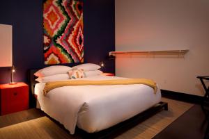 查塔努加的住宿－Hotel Clemons，卧室配有一张白色大床,墙上挂有绘画作品