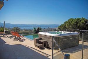 a hot tub on a patio next to a swimming pool at La Casa San Biaggio in Ajaccio