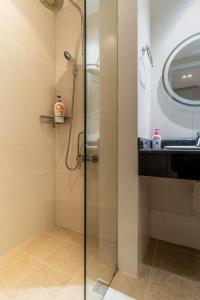 une douche avec une porte vitrée à côté d'un lavabo dans l'établissement The Rixx Lancaster Apartment, à Hô-Chi-Minh-Ville 19 autres photos