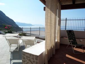 een balkon met tafels en stoelen en uitzicht op de oceaan bij Salina perla verde in Leni