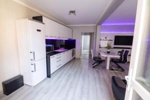a kitchen with white cabinets and a table with chairs at WhiteHouse in Arad