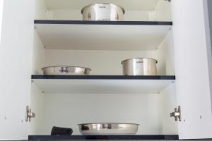 a kitchen with two shelves with pots and pans at WhiteHouse in Arad