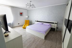 een slaapkamer met een bed met paarse lakens en paarse kussens bij WhiteHouse in Arad
