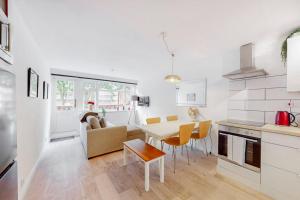 a kitchen and living room with a table and chairs at Modern 4BD house with a private patio in Islington in London