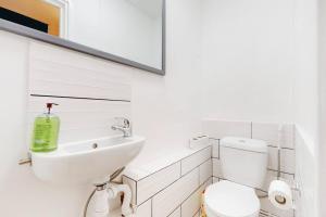 a white bathroom with a sink and a toilet at Modern 4BD house with a private patio in Islington in London