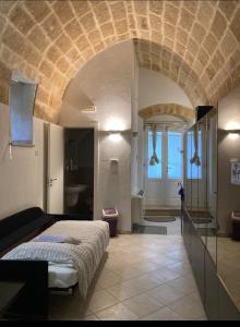 a bedroom with a large bed and a bathroom at S@sso Matto in Matera