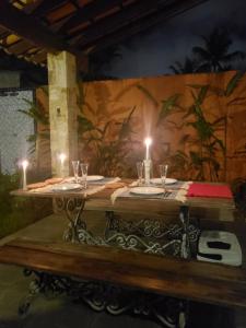 a wooden table with two candles on top of it at Casa Praia Jd Acapulco in Guarujá